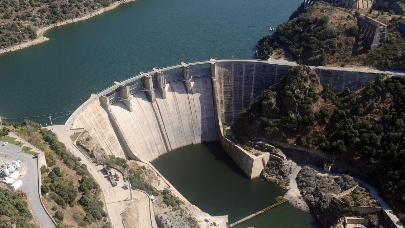 Vue aérienne d'un barrage hydroélectrique avec un réservoir d'eau en contrebas.