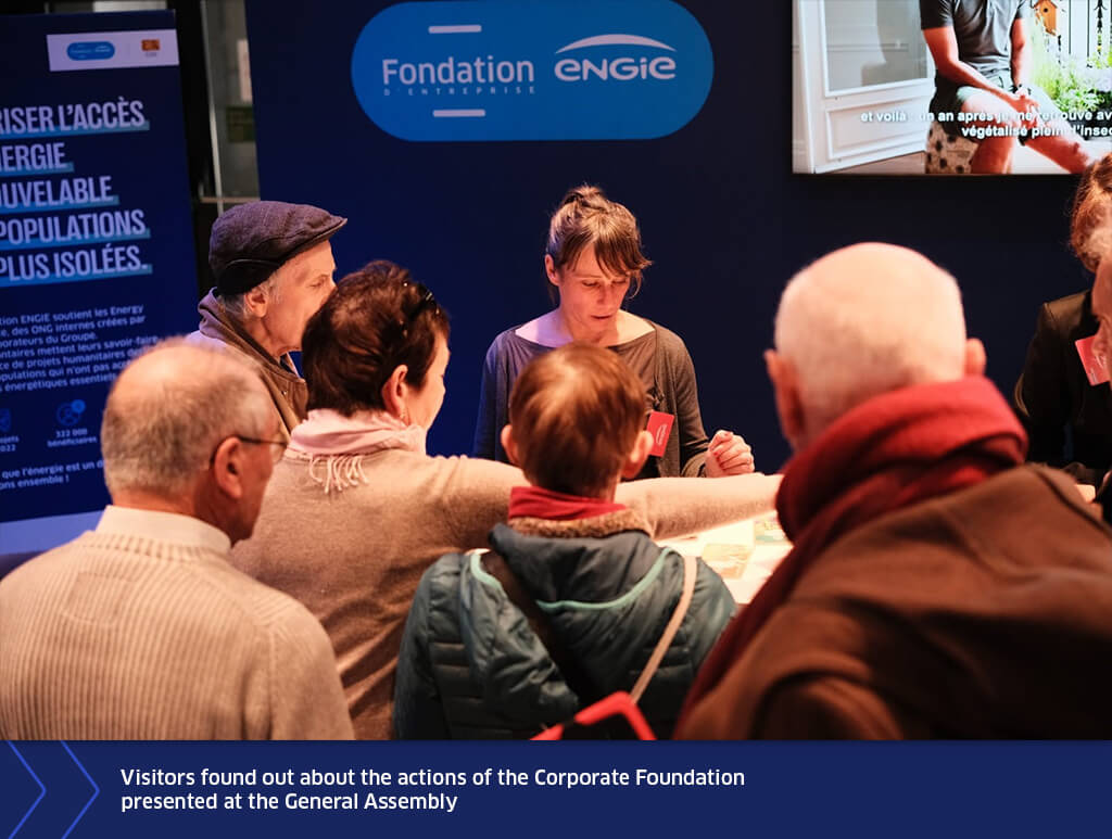 Visitors gathered around the ENGIE Corporate Foundation stand during the General Assembly, listening to a presentation about the foundation’s initiatives.